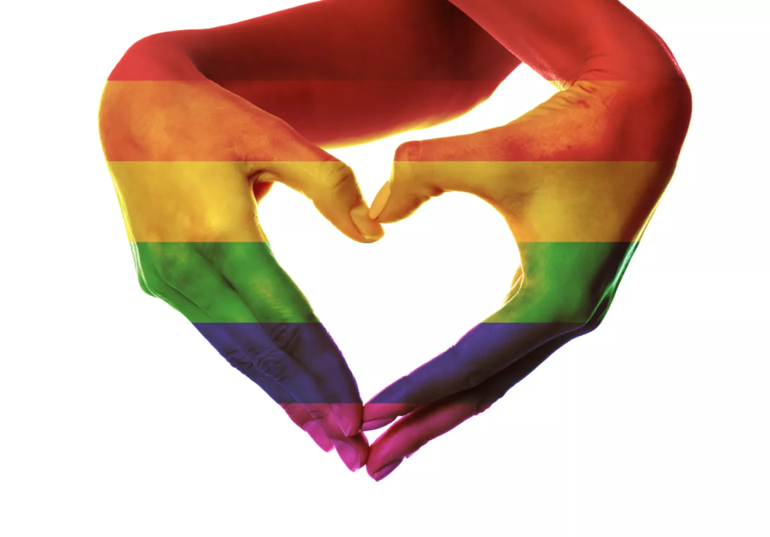 Female hands painted as the rainbow flag making heart on white background. LGBTQIA+ concept