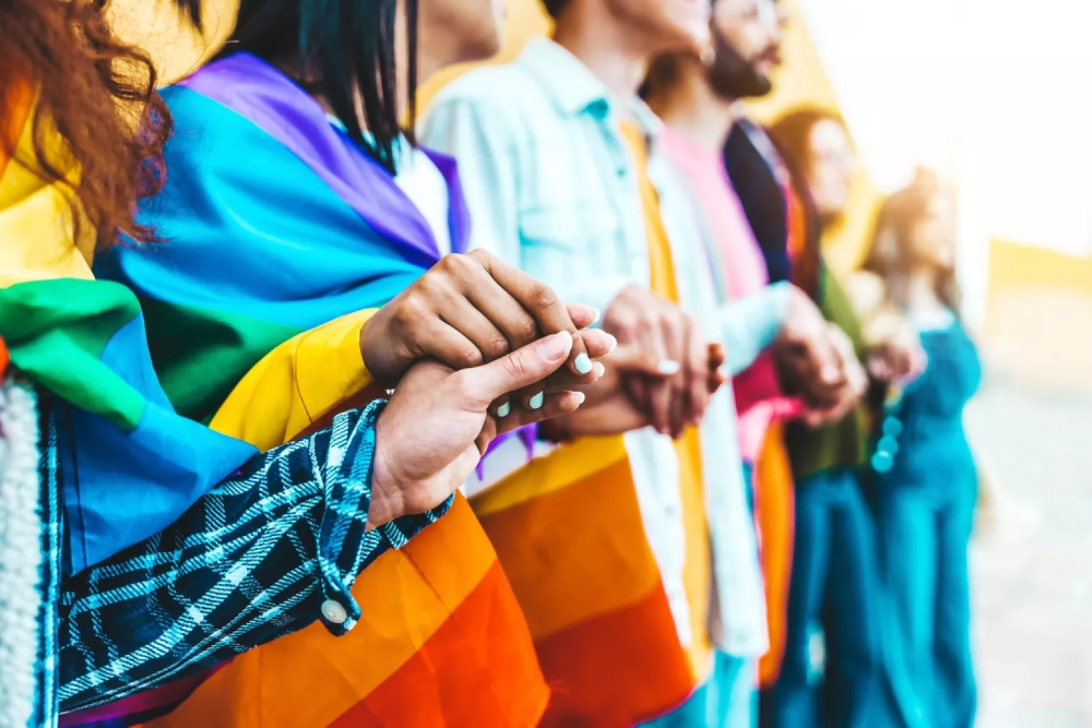 Group of lgbtia+ people holding hands outside