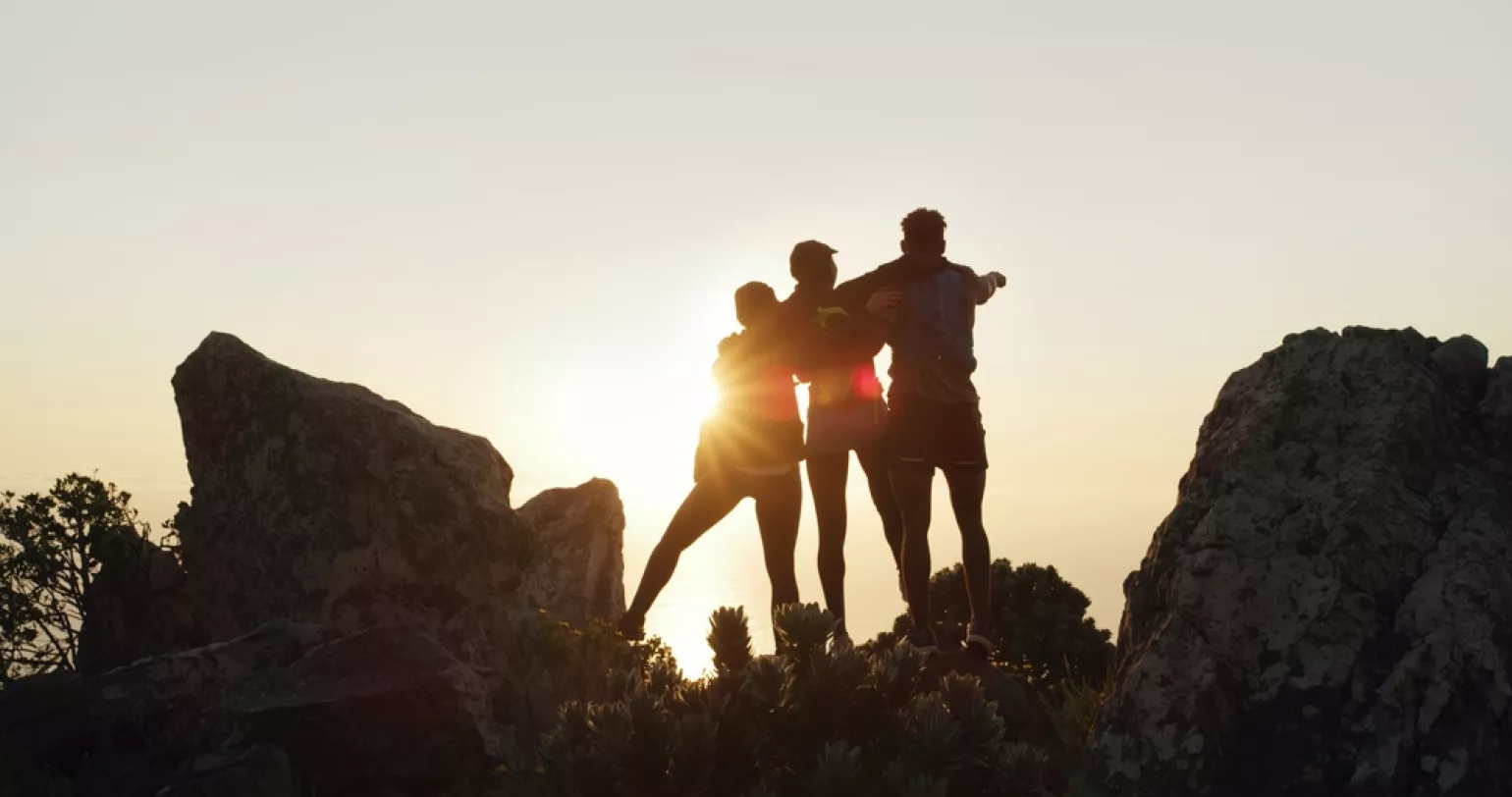 Silhouette of hands holding in front of a bright sunset