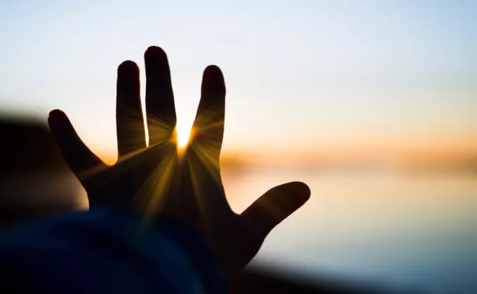 Hand touching the sun