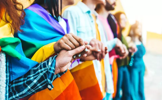 Group of lgbtia+ people holding hands outside