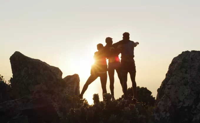 Silhouette of hands holding in front of a bright sunset