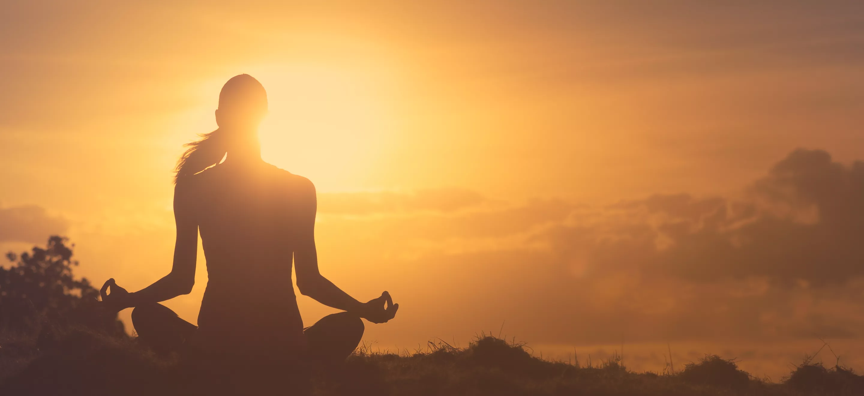 Woman meditating in the sunset