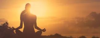 Woman meditating in the sunset