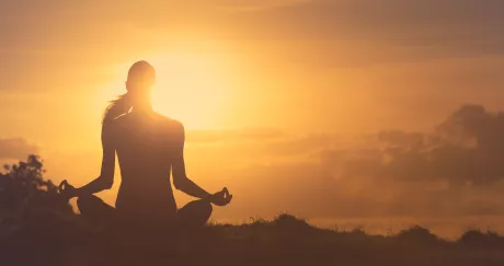 Woman meditating in the sunset