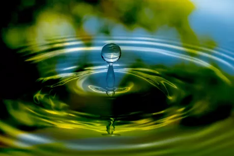 Water drop falling into nature surface. 