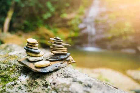 Rock stones stacking resting on top of each other, waterfall background
